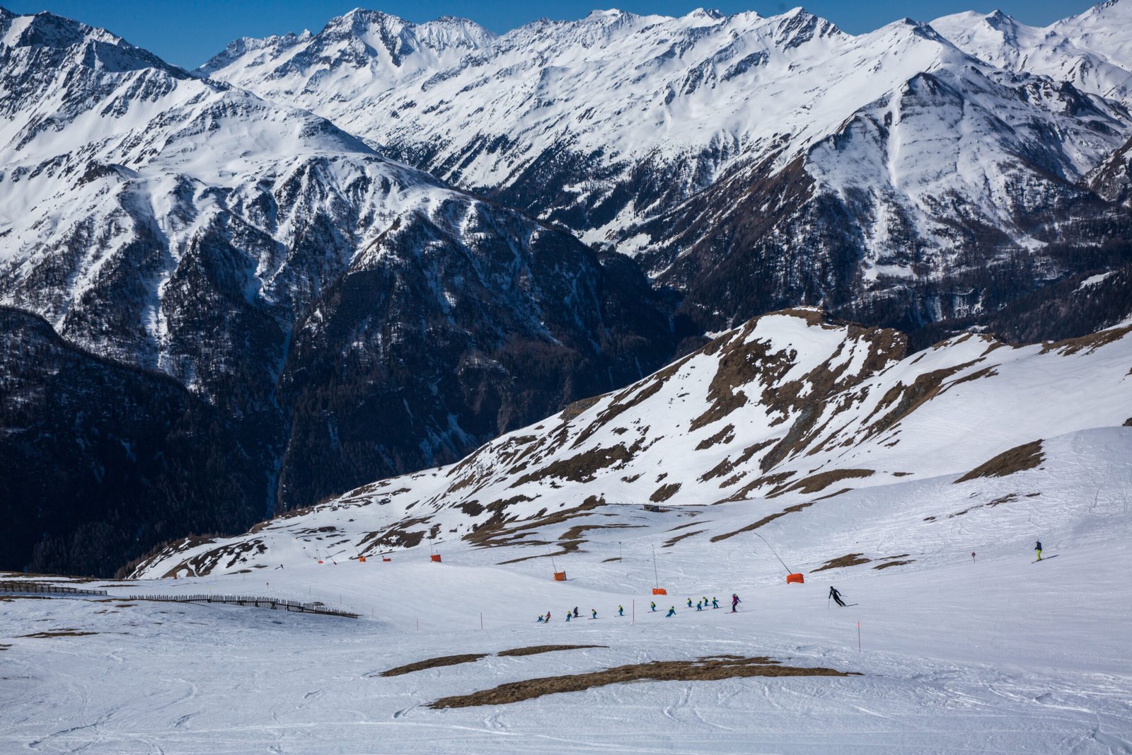 Many skiers ride in Alps at sunny winter day. Winter landscape - Panorama of the ski resort with ski slopes. Alps. Austria. Winter season